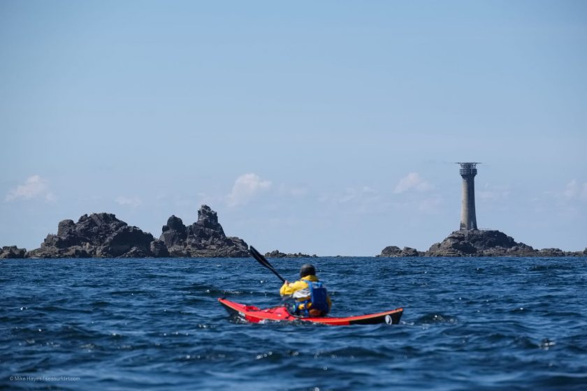 Longships lighthouse and sea kayaker on a sunny day